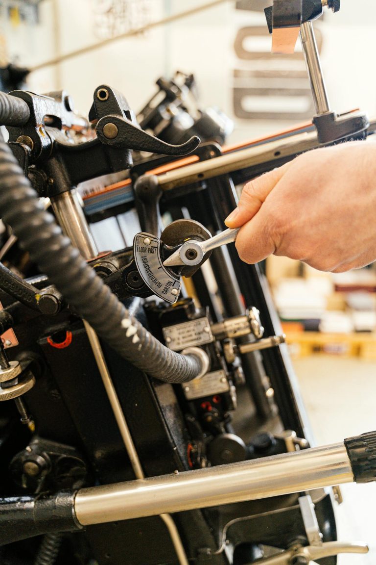 Detailed view of a hand adjusting industrial machinery settings.